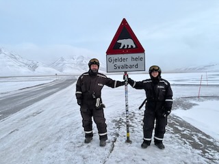 Alex and Grant at the Longyearbyen polar bear warning sign
